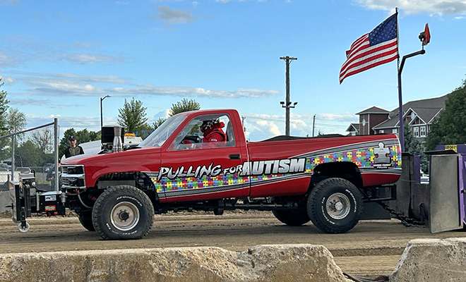 a red pick-up truck is ready to pull a sled at the NTPA truck and tractor pull at the Carver County Fair grandstand