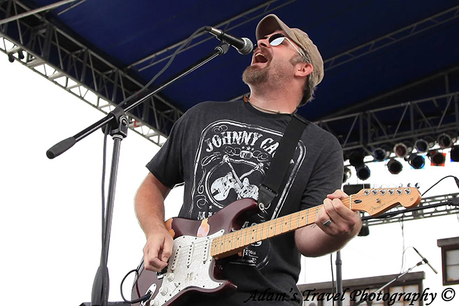 Jason Paulson playing guitar and singing