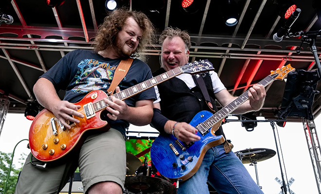 two guitar players in Muddcat Melby playing on stage