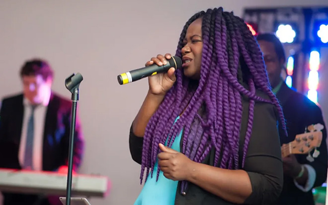 A woman in Power of 10 singing